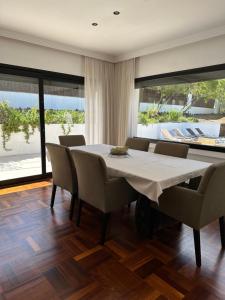 圣塔克里斯蒂纳阿鲁Villa Pirineus a beautiful villa with pool的一间配备有白色桌椅的用餐室