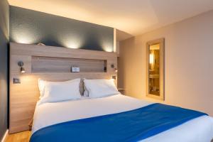 迪涅莱班迪涅莱班凯里亚德酒店的一间卧室配有一张带蓝色毯子的大床