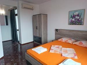 切尔诺莫雷茨Coral Family Hotel的一间卧室配有橙色的床和橱柜