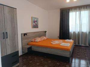 切尔诺莫雷茨Coral Family Hotel的一间卧室配有带橙色床单和枕头的床。