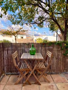 阿尔啼Hostal del vino LA COSTERA的一张带两把椅子的木桌和绿色花瓶