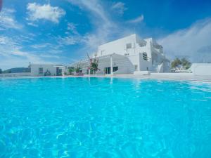 阿克罗蒂里The Fisherman's House Santorini的白色建筑前的蓝色海水游泳池