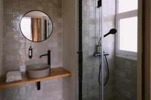AfaL'Orangeraie d'Afa的设有带镜子和水槽的淋浴的浴室