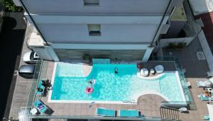 里米尼帕乌拉别墅酒店的游泳池的顶部景色,里面的人