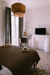 AfaL'Orangeraie d'Afa的一间卧室配有一张带椅子的床和一台电视