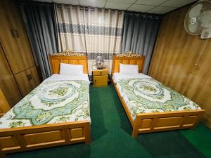 锡卡都Blue Sky Hotel & Restaurant的两张睡床彼此相邻,位于一个房间里
