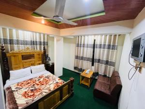 锡卡都Blue Sky Hotel & Restaurant的一间卧室配有一张床、一张沙发和一台电视。