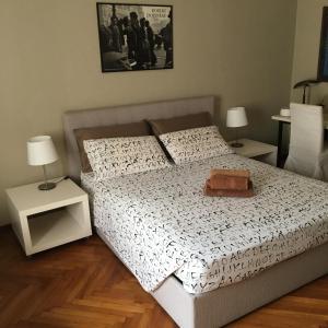 都灵Casa Crema Bed & Breakfast的一间卧室配有一张带两张桌子和两盏灯的床。