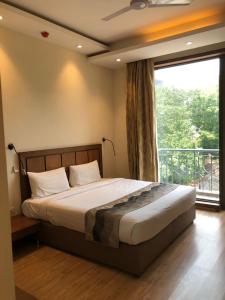 新德里UDS Villa Scandinavian B&B - Next to VFS的一间卧室设有一张床和一个大窗户