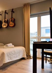 比得哥什Kamienica Poznańska 7的卧室配有一张床,墙上配有吉他