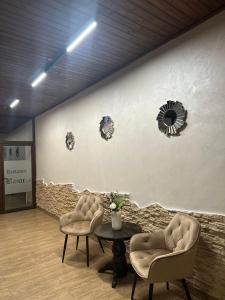 波亚纳布拉索夫Hotel Soimul的一间设有两把椅子、一张桌子和一面墙的房间