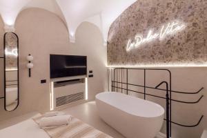 巴勒莫Pànto - Rooftop boutique rooms的一间卧室配有一张床、一台电视和一个浴缸