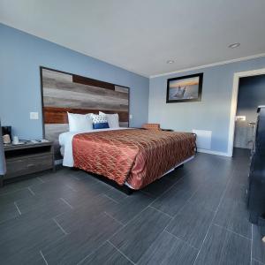 圣佩德罗Guest Harbor Inn- Port Of Los Angeles San Pedro的一间卧室配有一张大床和木制床头板