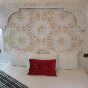 梅克内斯Golf Stinia hôtel & Spa的卧室配有白色的床和红色枕头