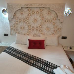 梅克内斯Golf Stinia hôtel & Spa的卧室配有一张带两个红色枕头的大型白色床