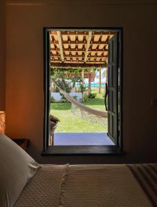 卡拉伊瓦Pousada Quintal Caraíva的卧室设有窗户,享有庭院的景色