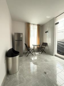 阿雷基帕Casa Vallecito的配有冰箱和桌椅的客房
