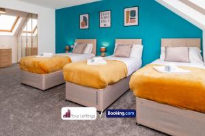 彼得伯勒Luxury 6 Bedroom Contractor House By Your Lettings Short Lets & Serviced Accommodation Peterborough With Free WiFi的蓝色墙壁客房的两张床