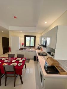 塞拉莱Hawana salalah Apartment的厨房配有一张带红色桌布的桌子