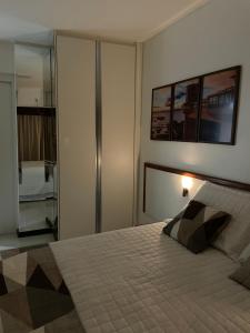 萨尔瓦多Apartamento beira mar localizado no Ondina Apart Hotel的一间卧室配有一张大床和镜子