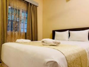 阿鲁甘湾Royal Point Arugambay的一间卧室设有两张带白色床单的床和窗户。