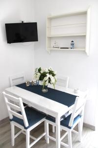 卡斯特拉玛雷帝斯达比亚I Balconcini Sul Porto的白色的餐桌、两把椅子和电视