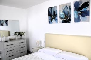 卡斯特拉玛雷帝斯达比亚I Balconcini Sul Porto的卧室配有一张床,墙上有三幅照片