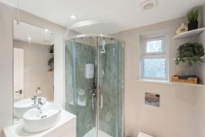 Flax BourtonCosy rural retreat North Somerset with garden的一间带玻璃淋浴和水槽的浴室
