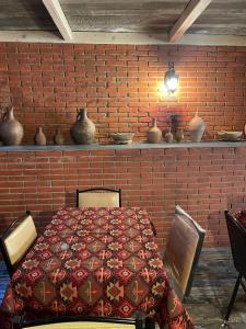 第比利斯MyFamily的一间设有红砖墙和桌子的用餐室