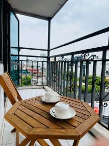 河内Hanoi Prime Garden Hotel & Spa的阳台上的木桌和椅子