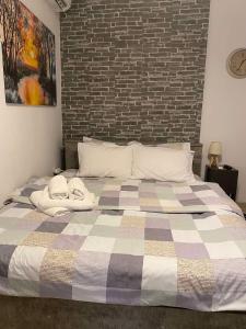 埃泽萨Central & Riverfront Room的一间卧室设有一张带砖墙的大床