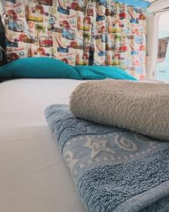 里斯本Autocaravana Dory的一张带蓝色枕头的床和一张毯子