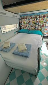 里斯本Autocaravana Dory的房间里的一张床位,上面有两条毛巾