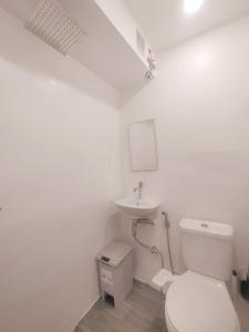 AdlawonVG Pension & Residences的白色的浴室设有卫生间和水槽。