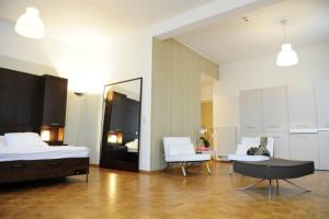卢森堡富豪齐客栈公寓酒店的一间卧室配有一张床、一把椅子和镜子