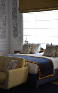 安特卫普Smartflats - Raphael Suites的一间卧室设有两张床、一个窗口和一张沙发