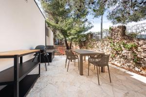 德拉格Tiny home Rubi in Oaza Mira resort的一个带桌椅的庭院和石墙
