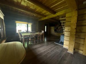 拉脱维亚Guest house Saulainie krasti的小屋内带桌椅的用餐室