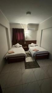 坦塔Royal hotel Tanta - فندق رويال طنطا的客房设有两张床和窗户。