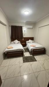 坦塔Royal hotel Tanta - فندق رويال طنطا的铺有瓷砖地板的客房内的两张床
