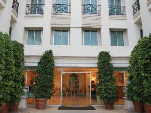 曼谷Romance Hotel Bangna的前面有树木的白色大建筑