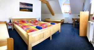 佩特里科夫Penzion Eliška的一间卧室配有一张带五颜六色棉被的木床