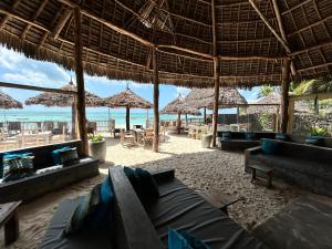江比阿Bahari Beach Bungalows的海滩上的客厅配有沙发和遮阳伞