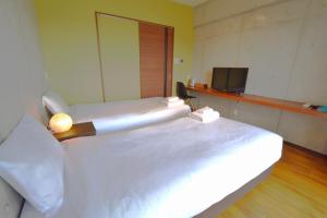 那霸Hotel Pescatore Okinawa的客房设有两张床和电视。