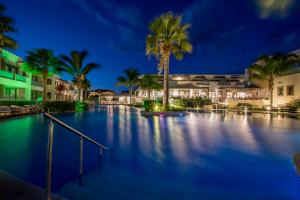 蒂锡利维Lesante Classic, a member of Preferred Hotels & Resorts的棕榈树和建筑的夜间游泳池