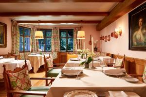 基茨比厄尔Relais & Châteaux Hotel Tennerhof的用餐室设有桌椅和窗户。