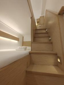 AdlawonVG Pension & Residences的楼梯通往卧室,卧室配有床