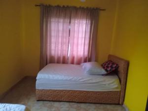 阿克拉Abokobi Cosy Home的一间卧室配有一张带白色床单窗户的床
