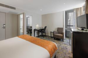 墨尔本墨尔本大臣酒店的酒店客房配有一张床、一张书桌和一台电视。