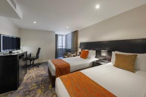 墨尔本墨尔本大臣酒店的酒店客房设有两张床和一台平面电视。
